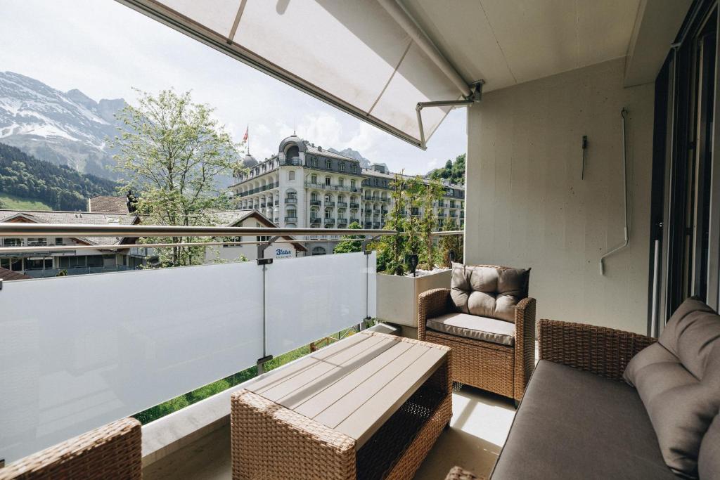 a balcony with wicker furniture and a view of a building at Apartment in Engelberg in Engelberg