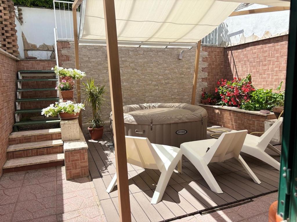 a patio with a grill and chairs and an umbrella at Villa Severino Ferrari in Anzio in Anzio