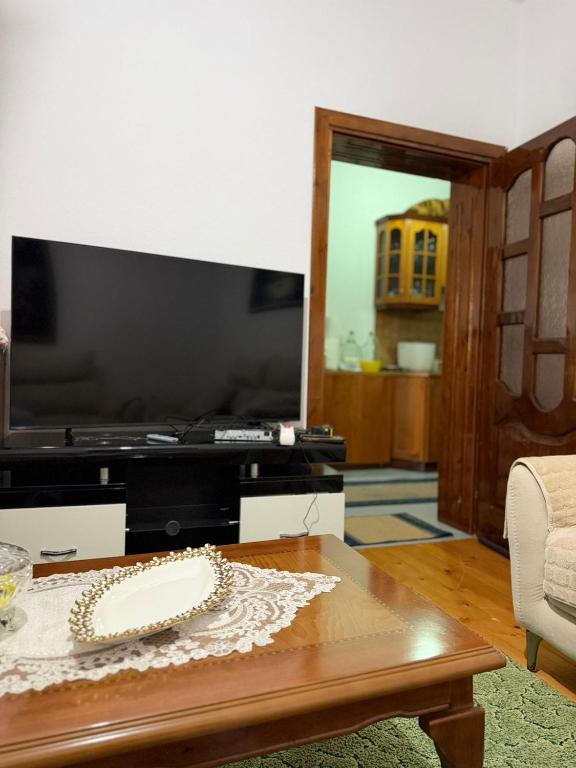 a living room with a table with a cake on it at Green House in Pogradec