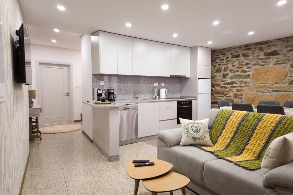 a living room with a couch and a kitchen at Casa da Goreti in Armamar