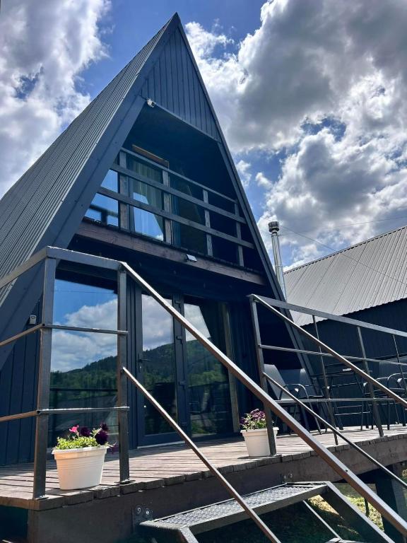 a blue house with stairs and potted plants on it at Diamond chalet A-frame in Ogrody