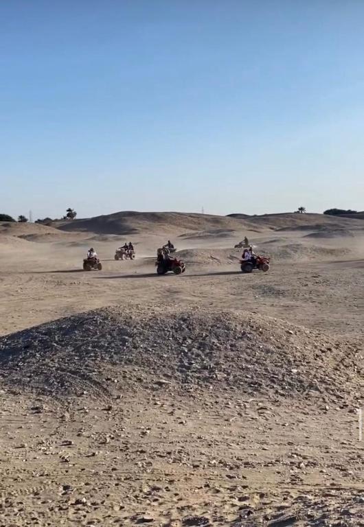 a group of people riding dirt bikes in the desert at Luxor Star ATV in Luxor
