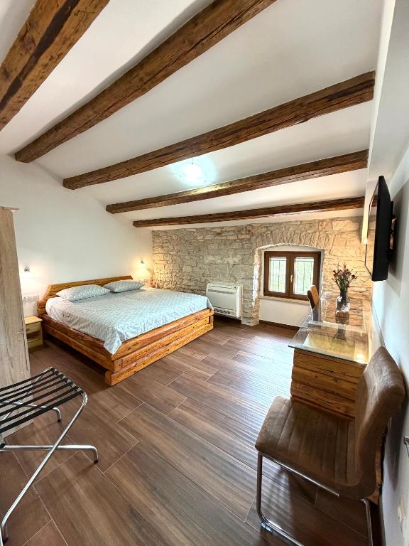 a bedroom with a bed and a stone wall at Tea Rooms III in Bale