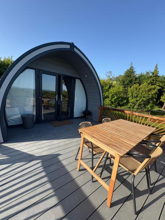 a wooden table and chairs on a deck with a tent at Celtic Glamping in Limerick