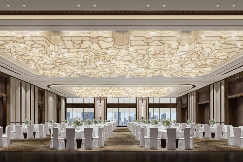 a banquet hall with white tables and white chairs at Sheraton Tengzhou in Zhaozhuang