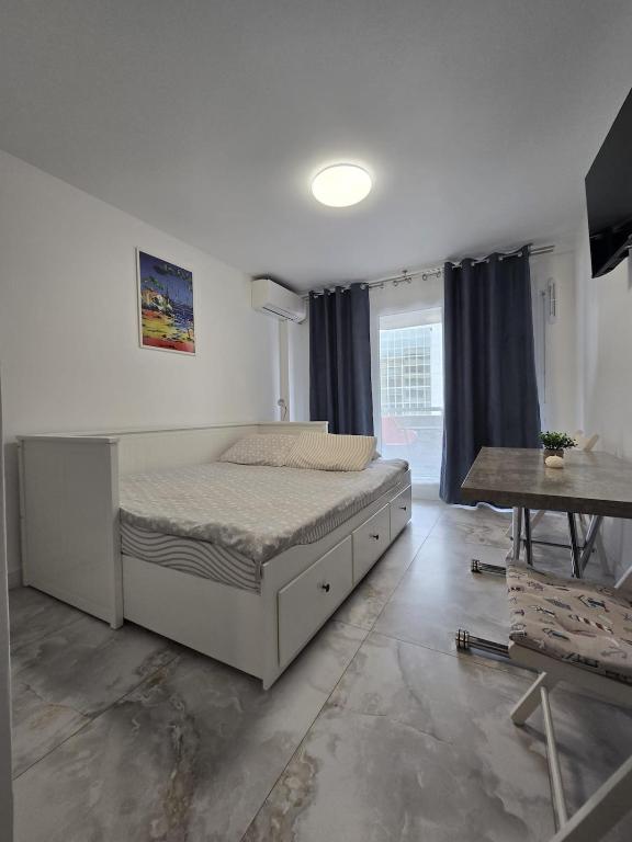 a bedroom with a large bed and a table at Cozy Seaside Studio with Private Parking in Nice