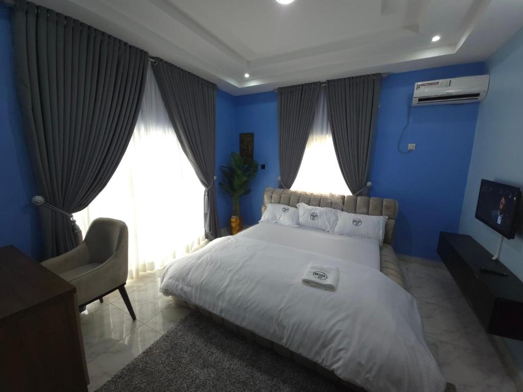 a blue bedroom with a bed and a chair at House 27 in Idu