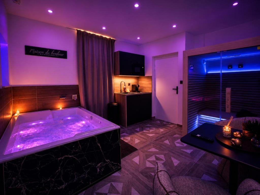 a room with a large tub with purple lighting at Hermitage Spa in Dijon
