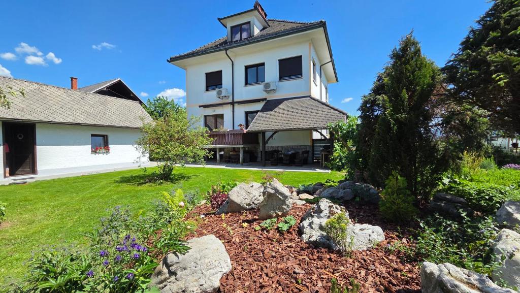 a large white house with a yard with rocks at Entire Villa for 6 near Bled -Private Garden, Grill & Free Parking in Lesce