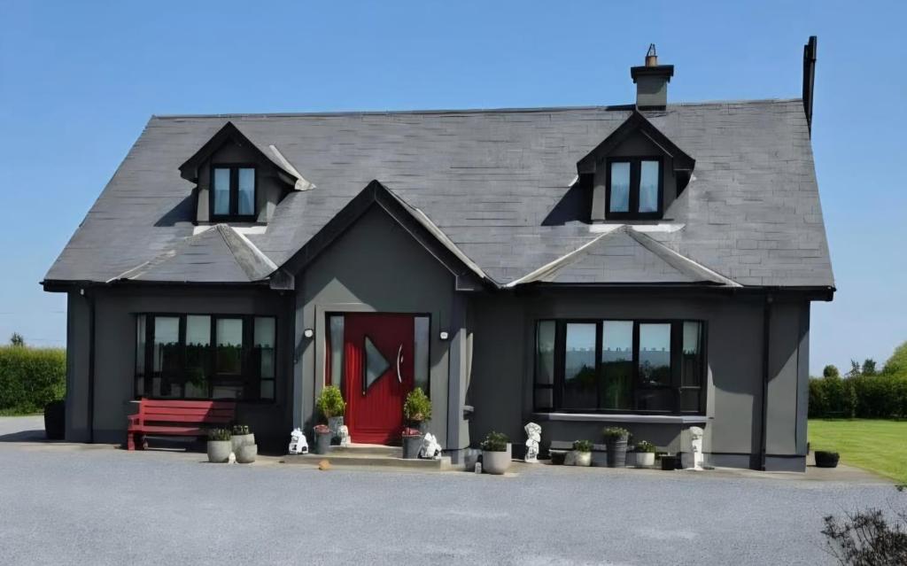 a black house with a red door at The Single Room in Killinick