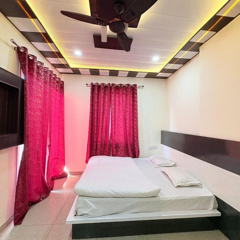 a bedroom with a bed and red curtains at Hotel Shyam Mahal Inn in Khātu