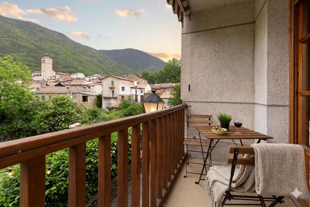 a balcony with a table and a view of a city at Treparriscos Home l Cine en casa l WIFI l Vistas in Biescas
