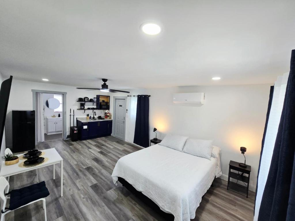 a bedroom with a white bed and a kitchen at Cozy Full Home Experience in Tampa