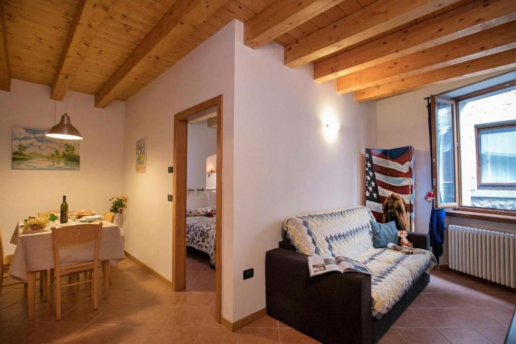 a living room with a couch and a dining room at Appartamento Centro Storico Riva - Happy Rentals in Riva del Garda