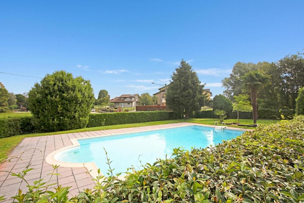 a swimming pool in a yard with bushes at Angera Relax & Pool - Lake Maggiore Retreat - Happy Rentals in Angera