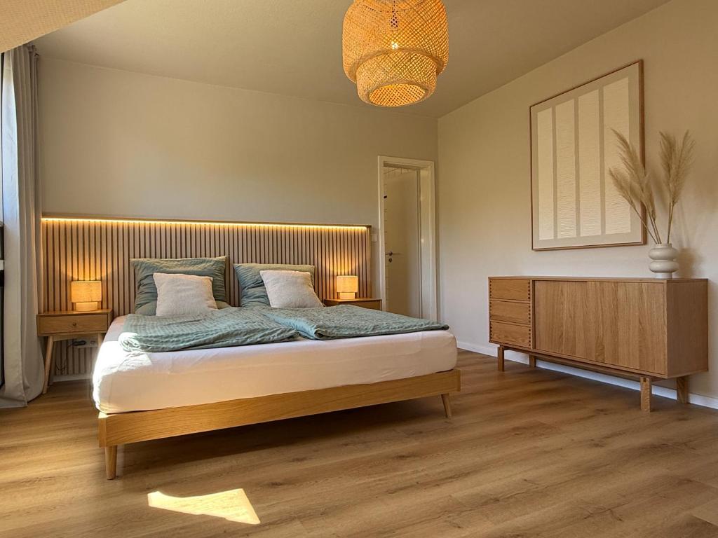 a bedroom with a bed with a wooden headboard at Strandloft Pippa in Borkum