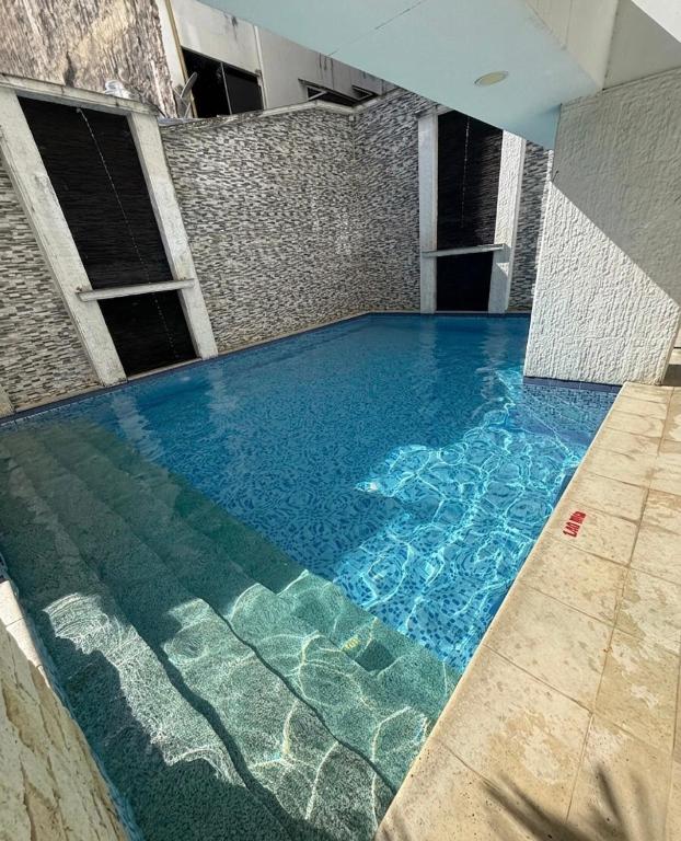 a swimming pool with blue water in a building at Luxury Suite with Pool in Melgar in Melgar