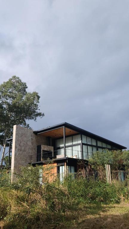 a large building with glass windows on top of a hill at lazy beach in Punta del Este