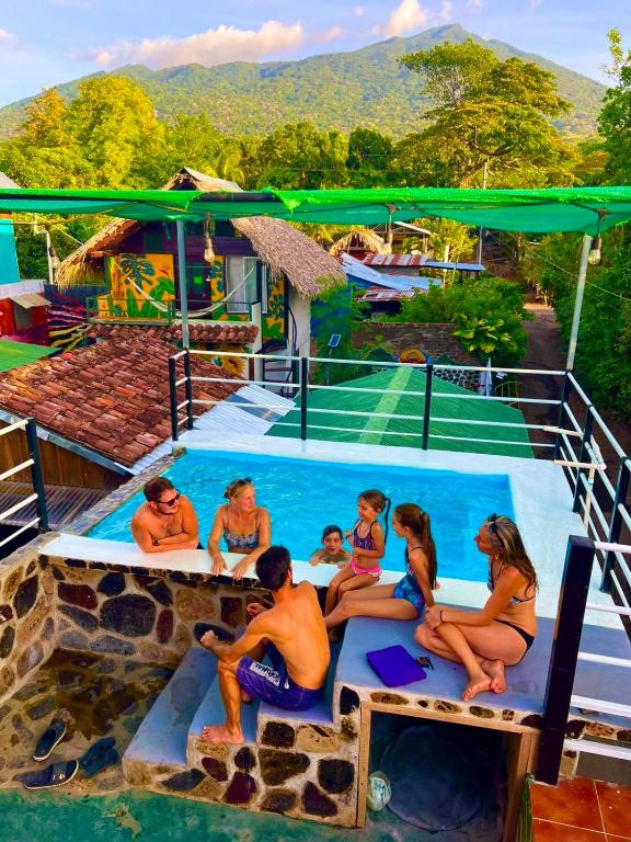 a group of people sitting around a swimming pool at Lazy Crab Hostel in Balgue