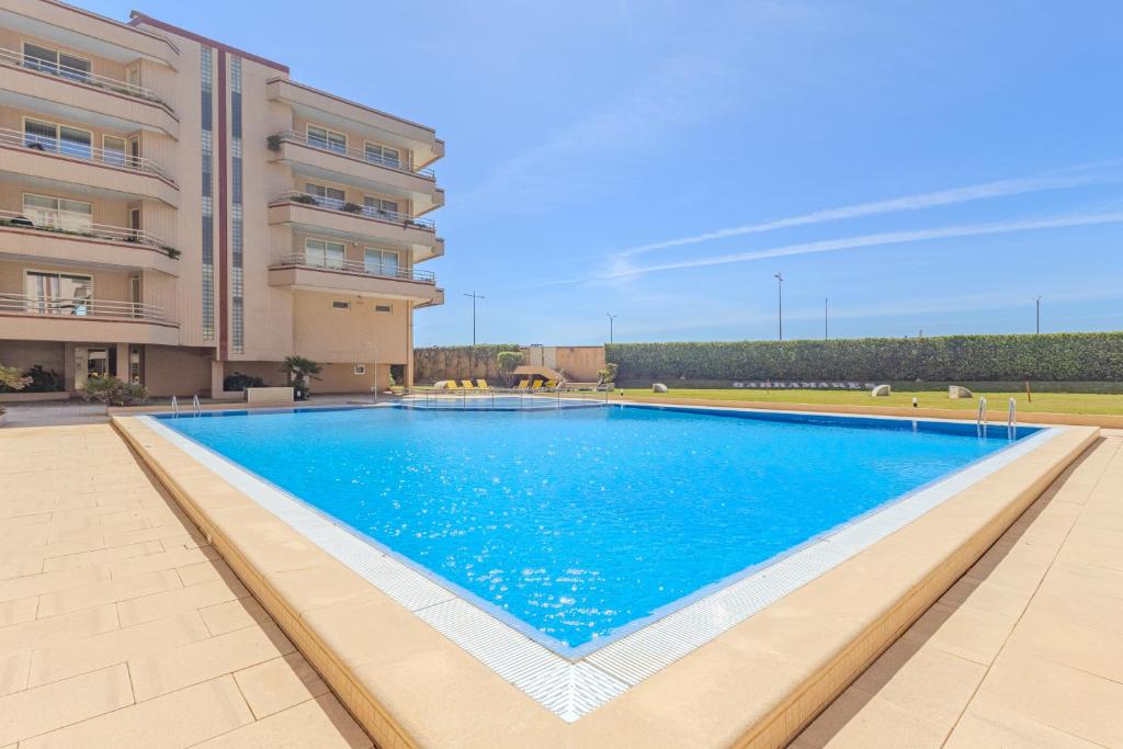 a large swimming pool in front of a building at Ocean View Luxury Duplex Apartment in Ovar