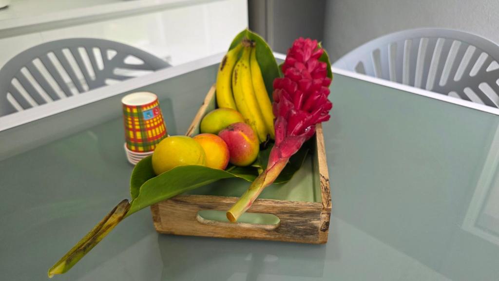 a wooden box filled with fruit on a table at Villa El Gato in Bouillante