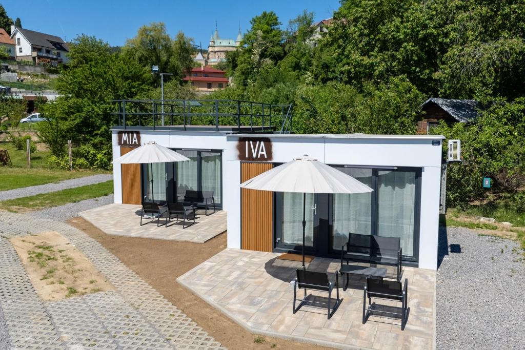 a small building with chairs and an umbrella at Ubytovanie Pod Farou Bojnice in Bojnice