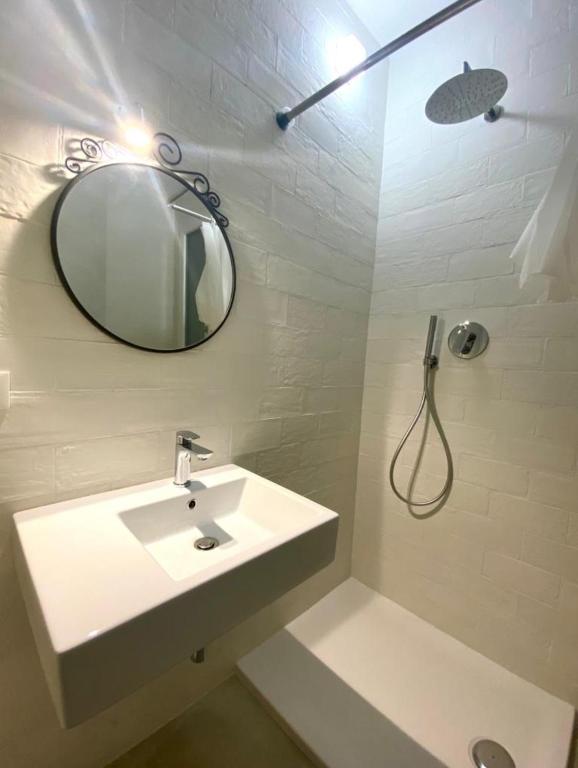 a white bathroom with a sink and a mirror at Arcadia Hosting Piazza XX Settembre in Bologna