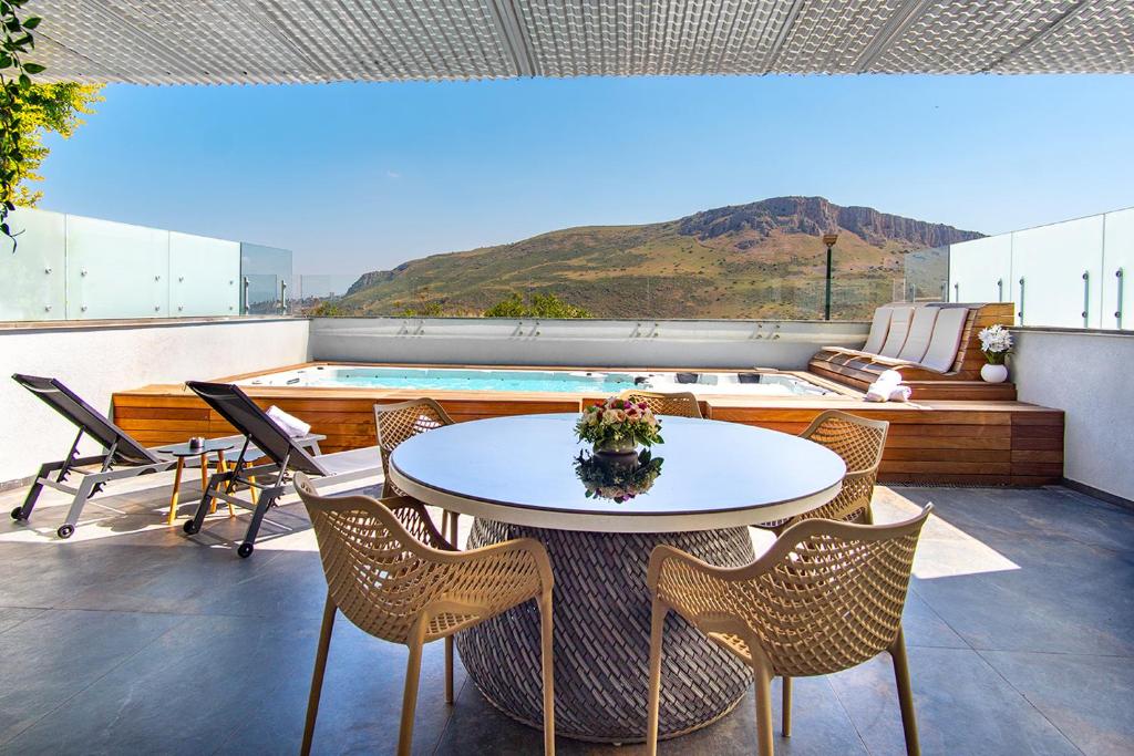 a patio with a table and chairs and a pool at מגדליה סוויט - סויטה למשפחות עם בריכת זרמים וגקוזי פרטיים in Migdal