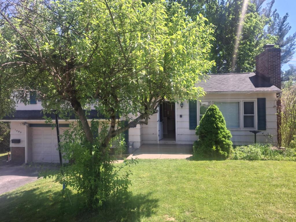 a house with a tree in the yard at Beach Vacation Home in Rochester