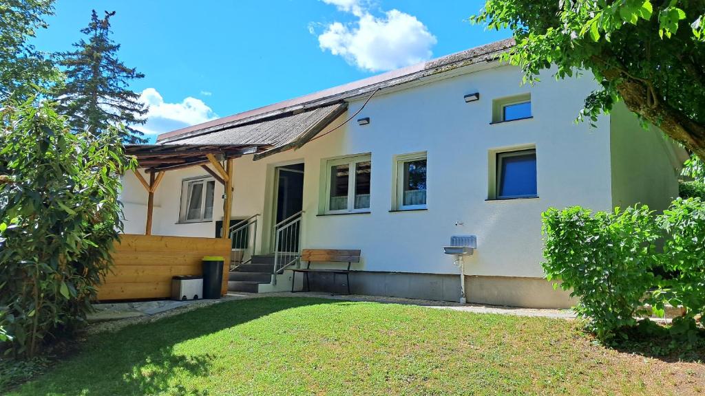 a white house with a fence and a yard at Das Gartenhaus - Lottstetten in Lottstetten