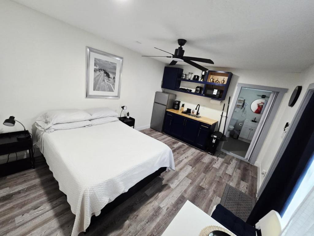 a bedroom with a white bed and a ceiling fan at Lovely Single Apartment in Tampa