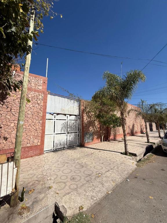 a parking lot with a gate and a brick building at complejo laprida in Santa Lucía