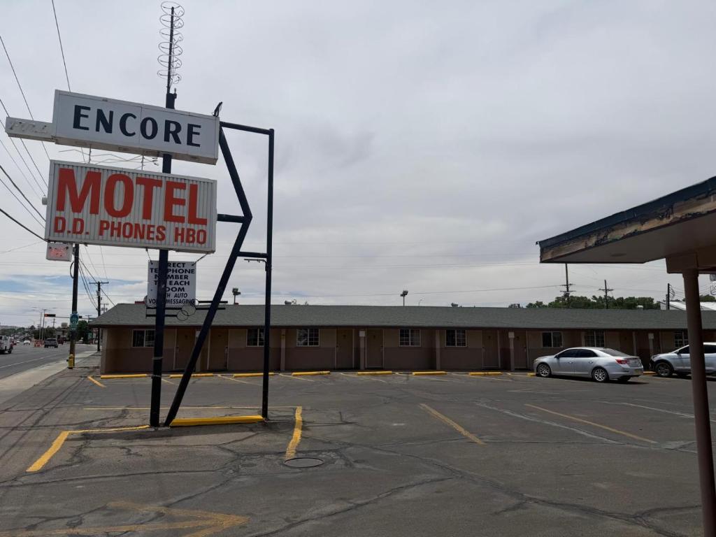 a motel sign in front of a parking lot at Encore Motel in Farmington