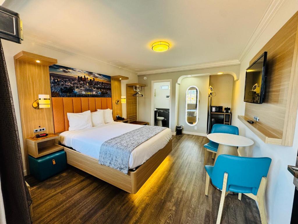 a hotel room with a bed and a table and chairs at The Lexmar - Dodger Stadium-Convention Center in Los Angeles