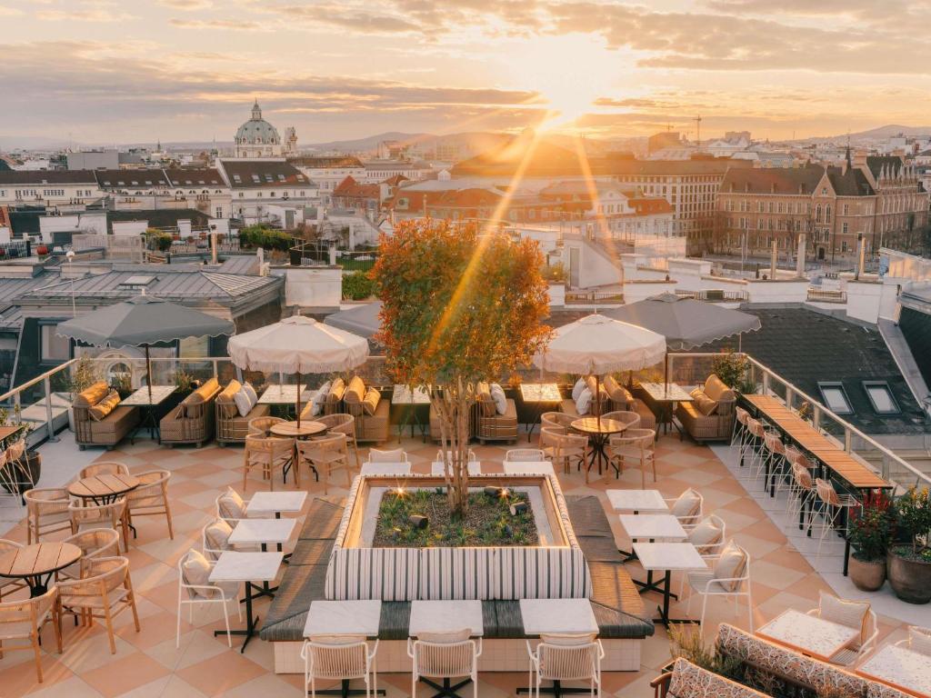 a view of a rooftop patio with tables and chairs at The Hoxton Vienna in Vienna