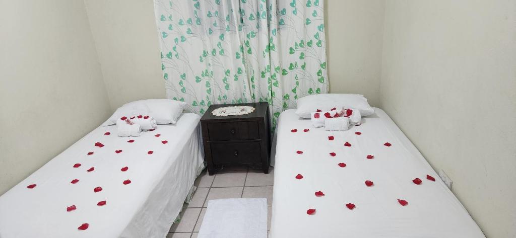 two beds in a room with red hearts on them at Hilltop View Guesthouse in Castries
