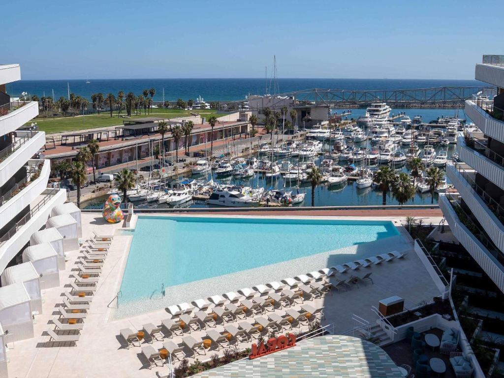 Luftaufnahme eines Jachthafens mit großem Swimmingpool in der Unterkunft SLS Barcelona in Barcelona