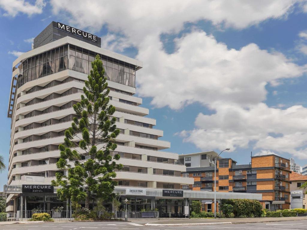 a large building with a tree in front of it at Mercure Brisbane Spring Hill in Brisbane