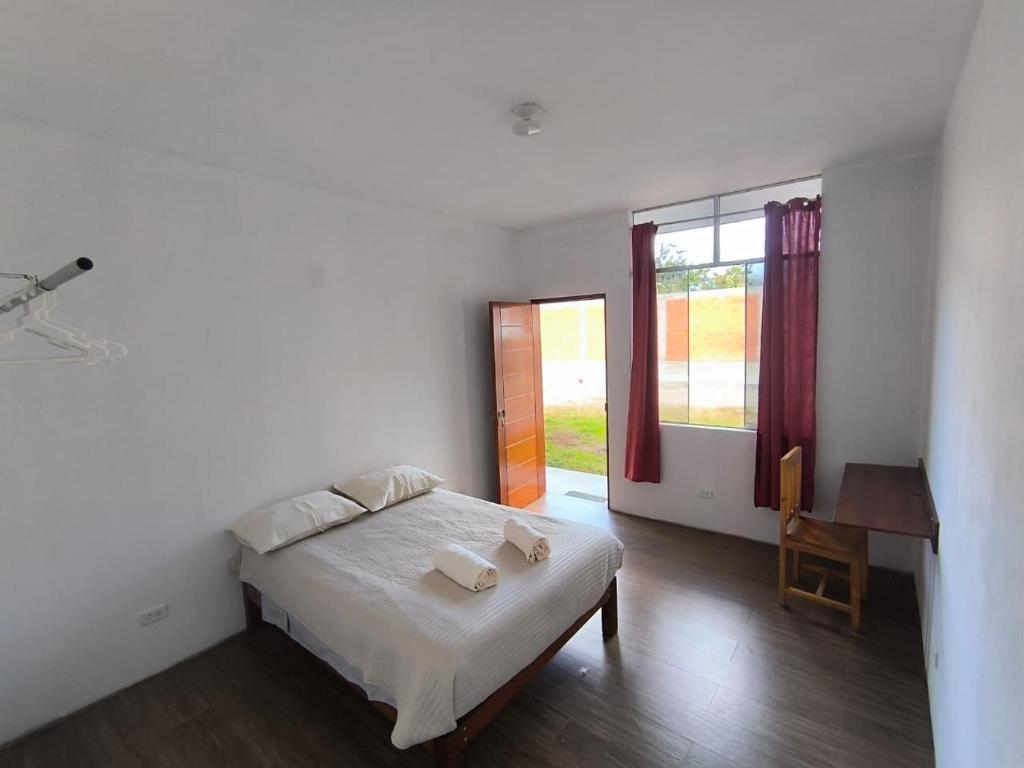 a bedroom with a bed and a desk and a window at JJ Guest House Kuelap in Nuevo Tingo