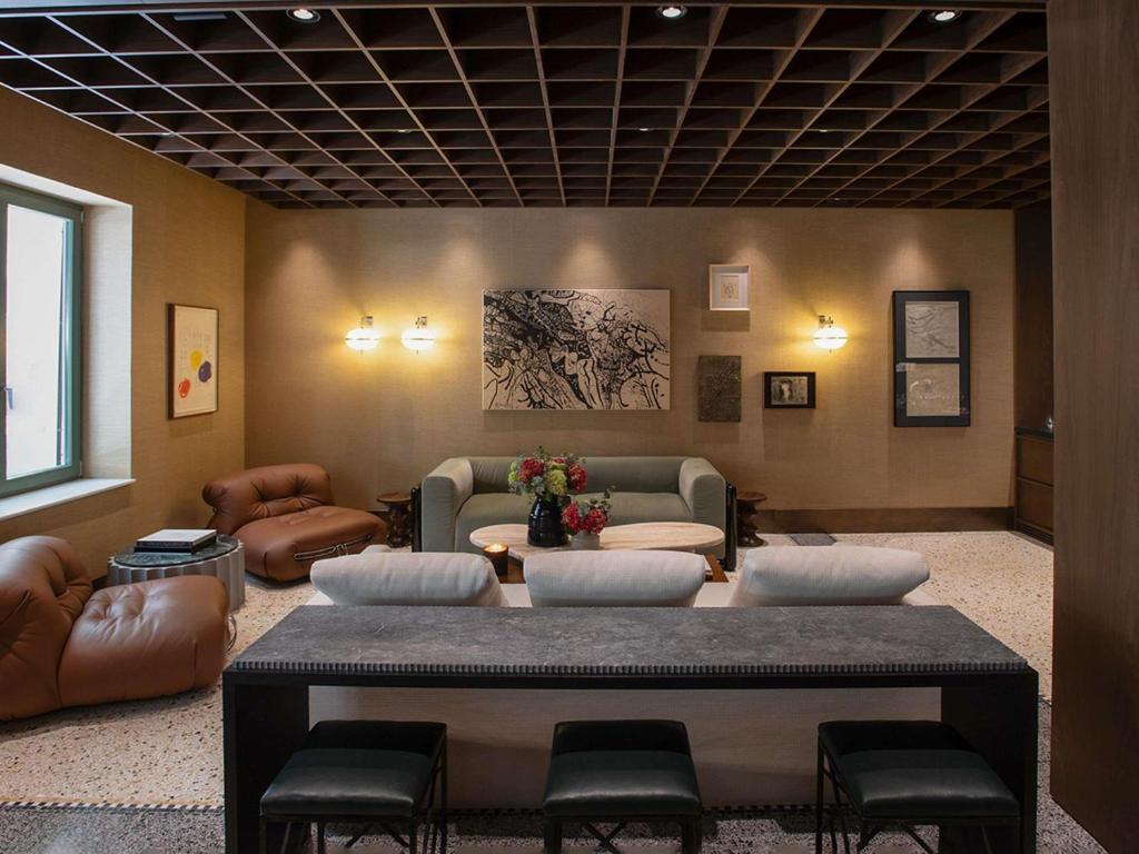 a waiting room with leather chairs and a table at Athens Capital Suites-MGallery Collection in Athens