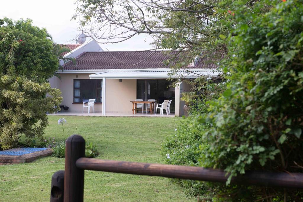 ein Haus mit einem Zaun vor einem Hof in der Unterkunft Sole's Leap in Scottburgh