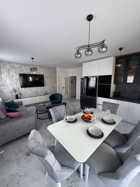 a kitchen and living room with a white table and chairs at Apartment Lumos in Ljubuški