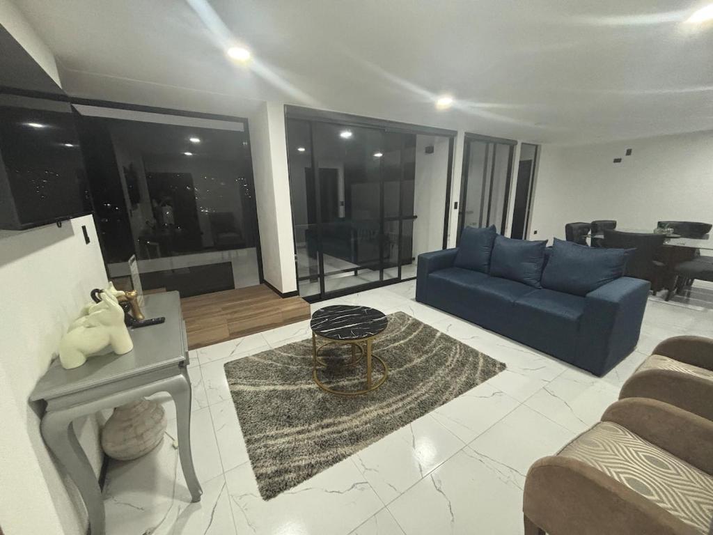 a living room with a blue couch and a table at Residencia familiar céntrica xalapa in Xalapa