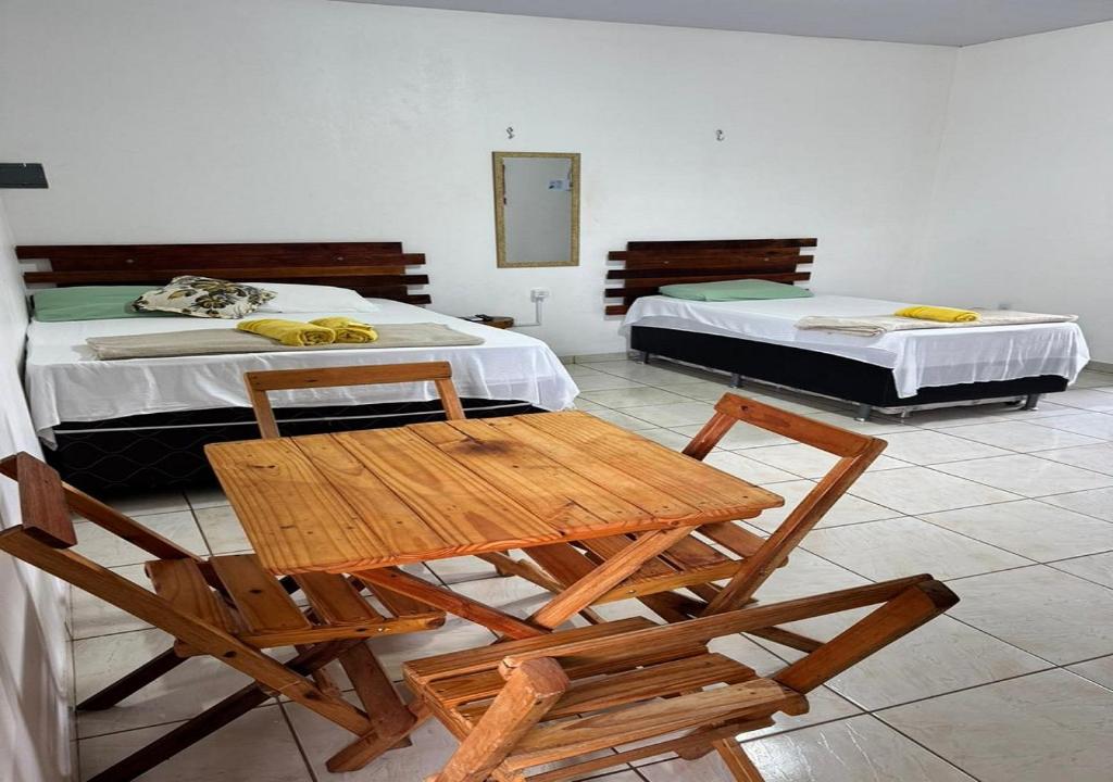 a room with two beds and a table and chairs at Margarida AP 3 in Presidente Figueiredo