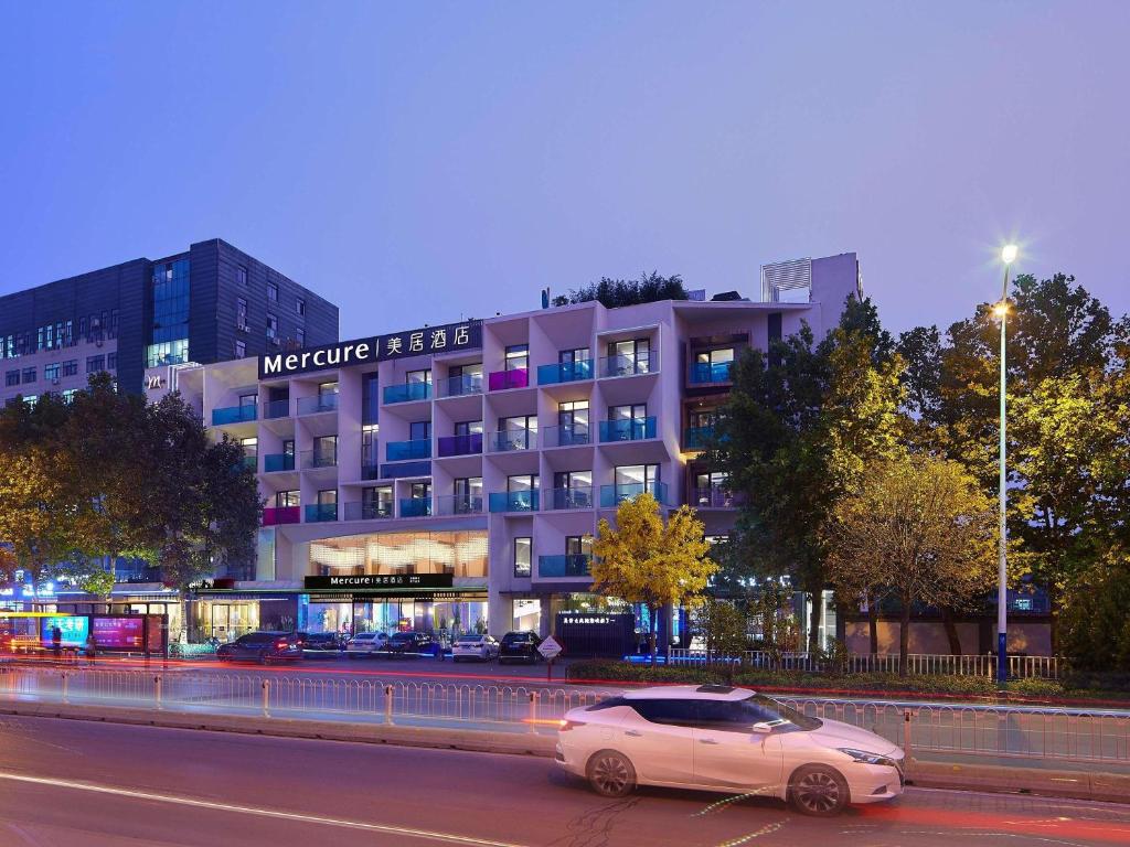 a white car parked in front of a building at Mercure Tai'an Centre in Tai'an