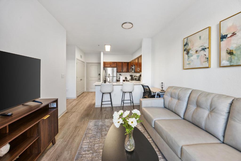 a living room with a couch and a tv at Relaxing Getaway with Pool view & Gym in Frisco