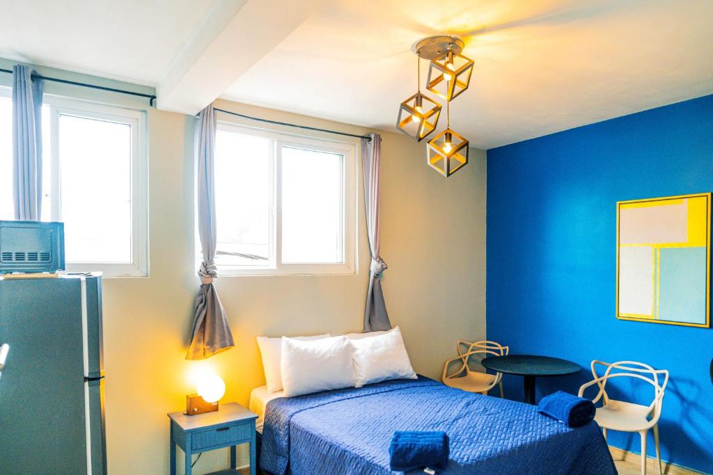 a bedroom with a bed and a blue wall at Villa Verona in Guatemala