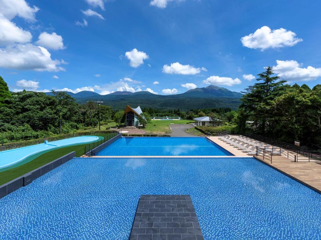 a swimming pool with a view of the mountains at The Pulse Kirishima- Opening in 16th Aug 2025 in Kirishima