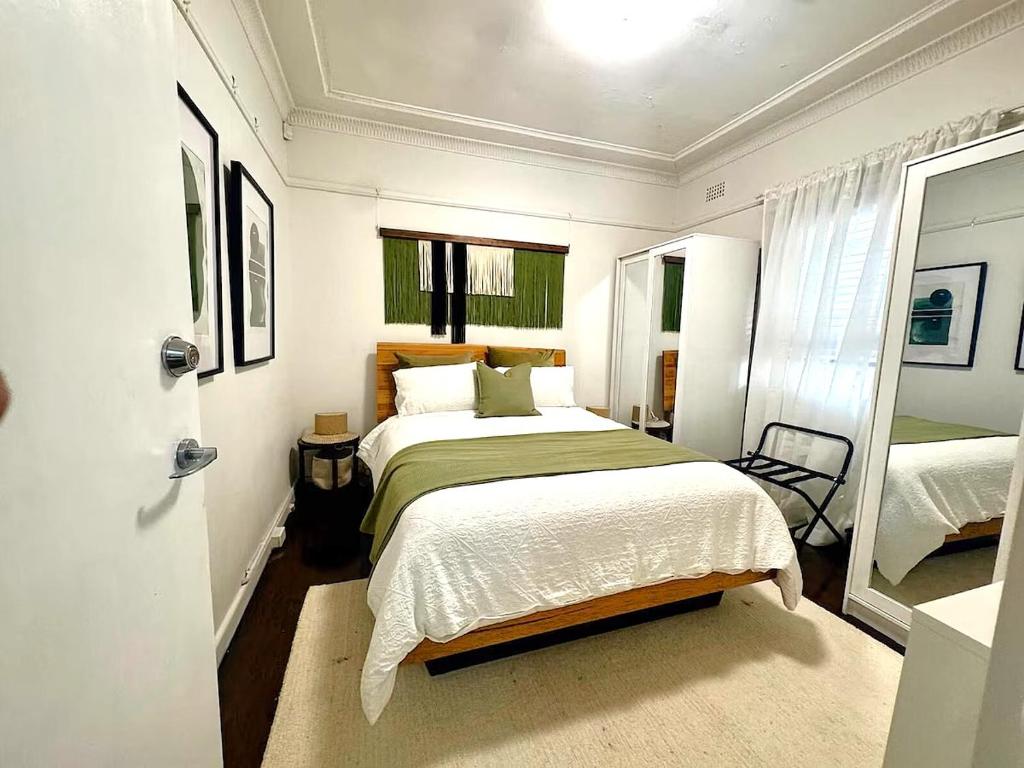 a bedroom with a large bed and a mirror at Pet Friendly Acer Arena Accommodation in Sydney