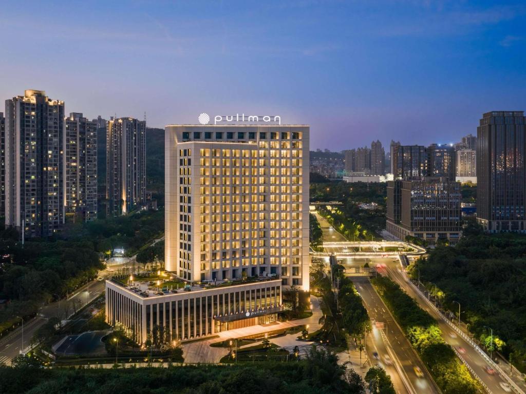 a lit up building in a city at night at Pullman Chongqing Xiyue in Chongqing